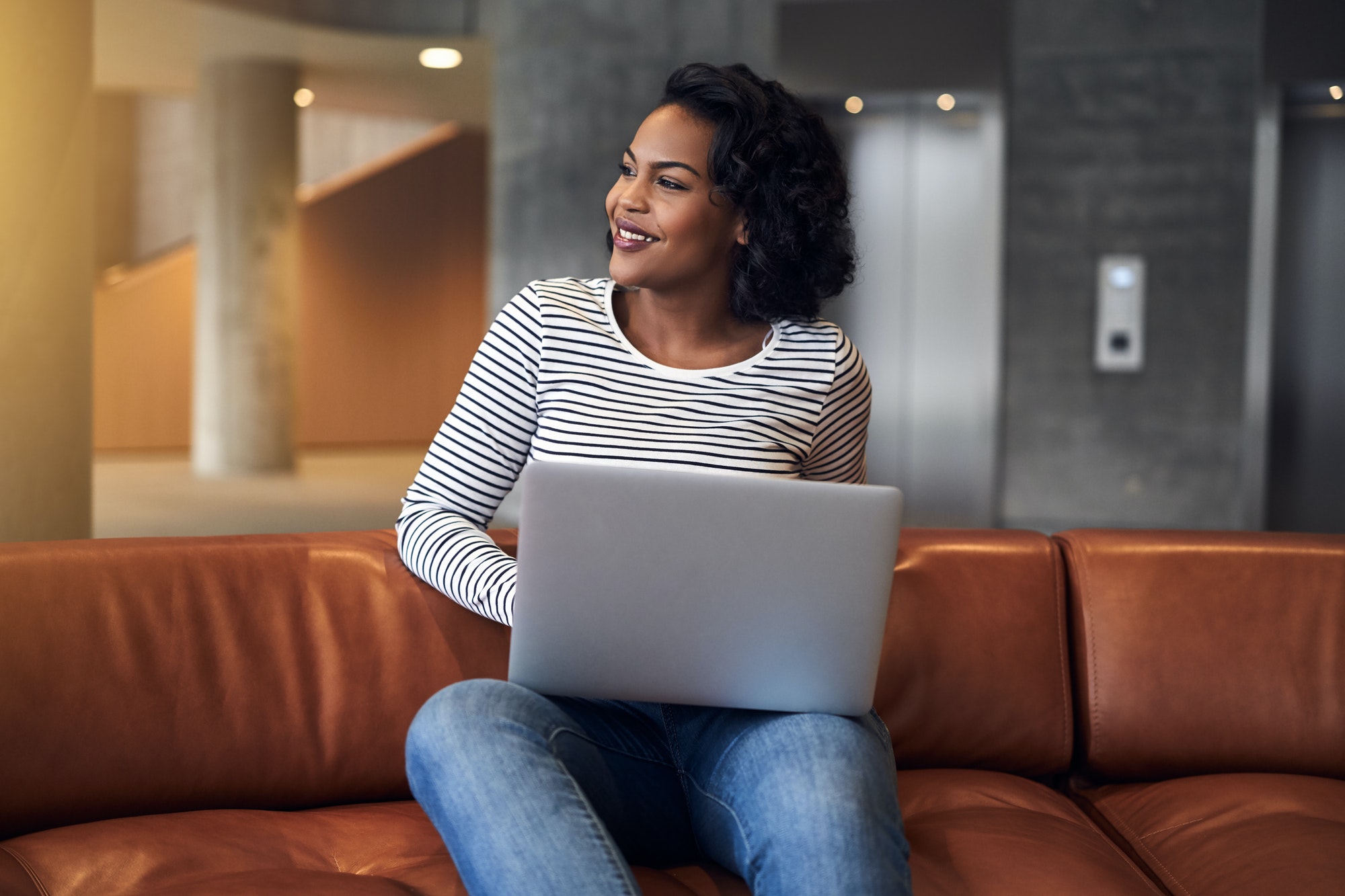 Smiling young African university student working online on campus