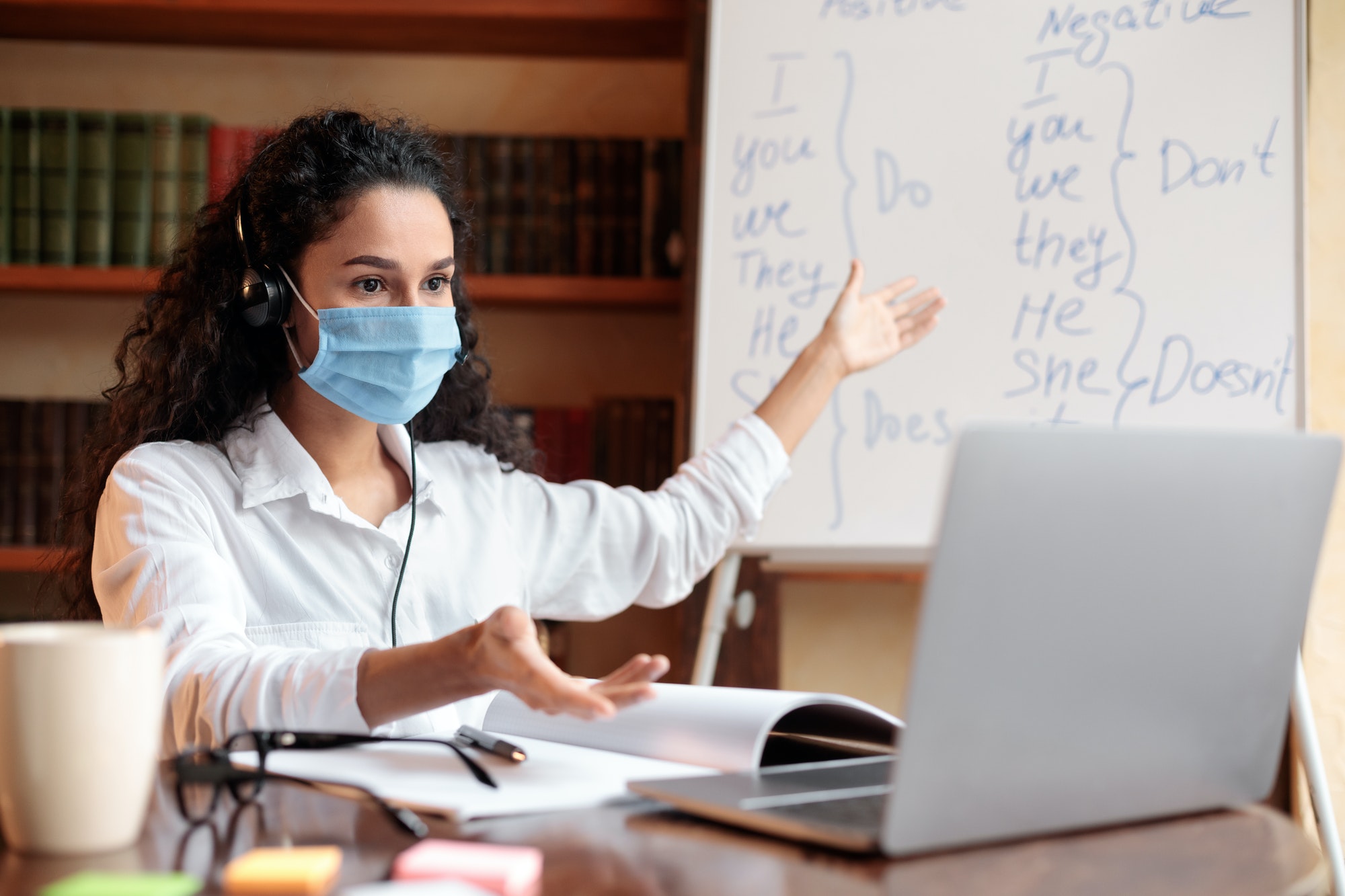 Teacher in mask having video conference chat with students